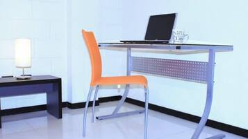 A modern office desk with a laptop, a chair, and a lamp.