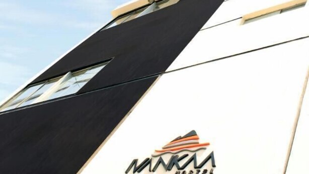 A building with a modern design, featuring a logo that reads "MARA HOSTEL" on its facade.