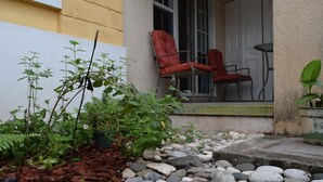 A garden with various plants and a stone pathway leading to a door. - Winchester 07A by Pro Homes Jamaica (Kingston)