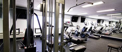 A gym with various exercise equipment, including treadmills and weight machines.