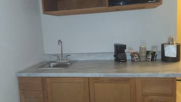 A kitchen with a built-in microwave, a sink, and wooden cabinets.