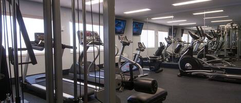 A gym with various exercise equipment, including treadmills and weight machines.
