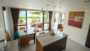 A modern kitchen with a dining area, large windows, and a view of the outdoors. - Dreamview Villas - In Rakiraki (Rakiraki)