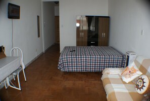 A bedroom with a bed, a wardrobe, a desk, and a chair. - Apartamento Helvetia (São Paulo)