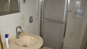 A bathroom with a sink, mirror, and shower. - Apartamento Helvetia (São Paulo)