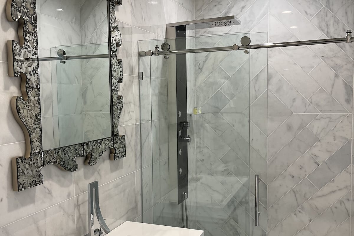 deluxe room | bathroom | shower, hydromassage showerhead, free toiletries, towels