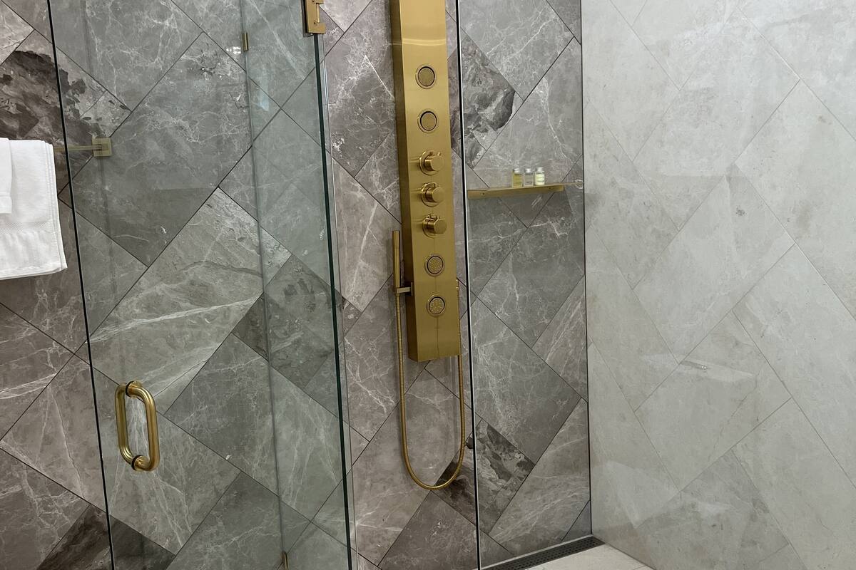 deluxe room | bathroom | shower, hydromassage showerhead, free toiletries, towels