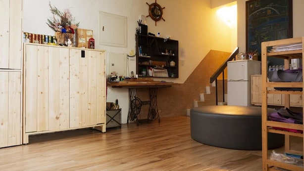 A kitchen with wooden cabinets, a sewing machine, and a staircase leading to a lower level. - OAOA Anping House (Tainan)