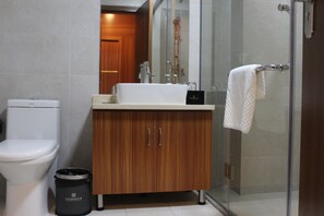 A modern bathroom with a toilet, sink, and shower. - Yi Hao International Apartment (Guangzhou)