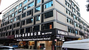 Un edificio de varios pisos con un letrero que indica Yun Hong International Apartment Hotel.