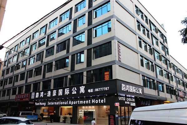 Un immeuble à plusieurs étages portant une enseigne indiquant « Yun Hong International Apartment Hotel ».