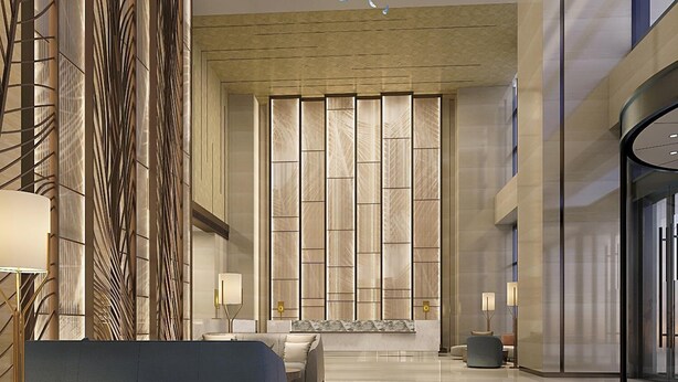 A modern lobby with a large seating area, a decorative wall with vertical panels, and a glass entrance. - Howard Johnson Zhujiang Hotel Chongqing (Chongqing)