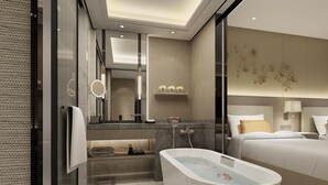 A modern hotel bathroom with a freestanding bathtub, a large mirror, and a vanity with a sink and towel rack. - Howard Johnson Zhujiang Hotel Chongqing (Chongqing)