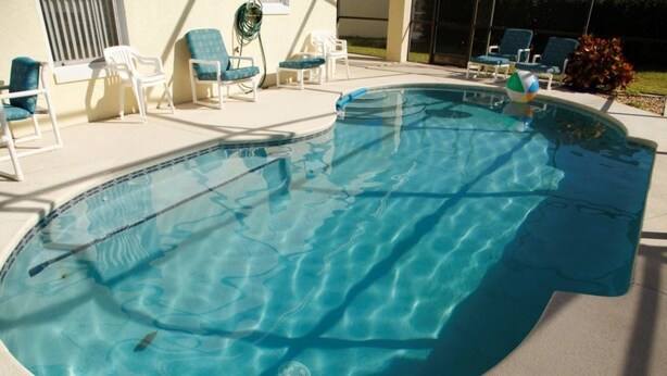 A swimming pool with clear blue water, surrounded by lounge chairs and a small garden area. - Ly53763 - Indian Ridge - 4 Bed 2 Baths Villa (Kissimmee)
