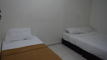 Quarto pequeno e limpo, com duas camas de solteiro, um banco marrom e uma parede branca com um quadro.
