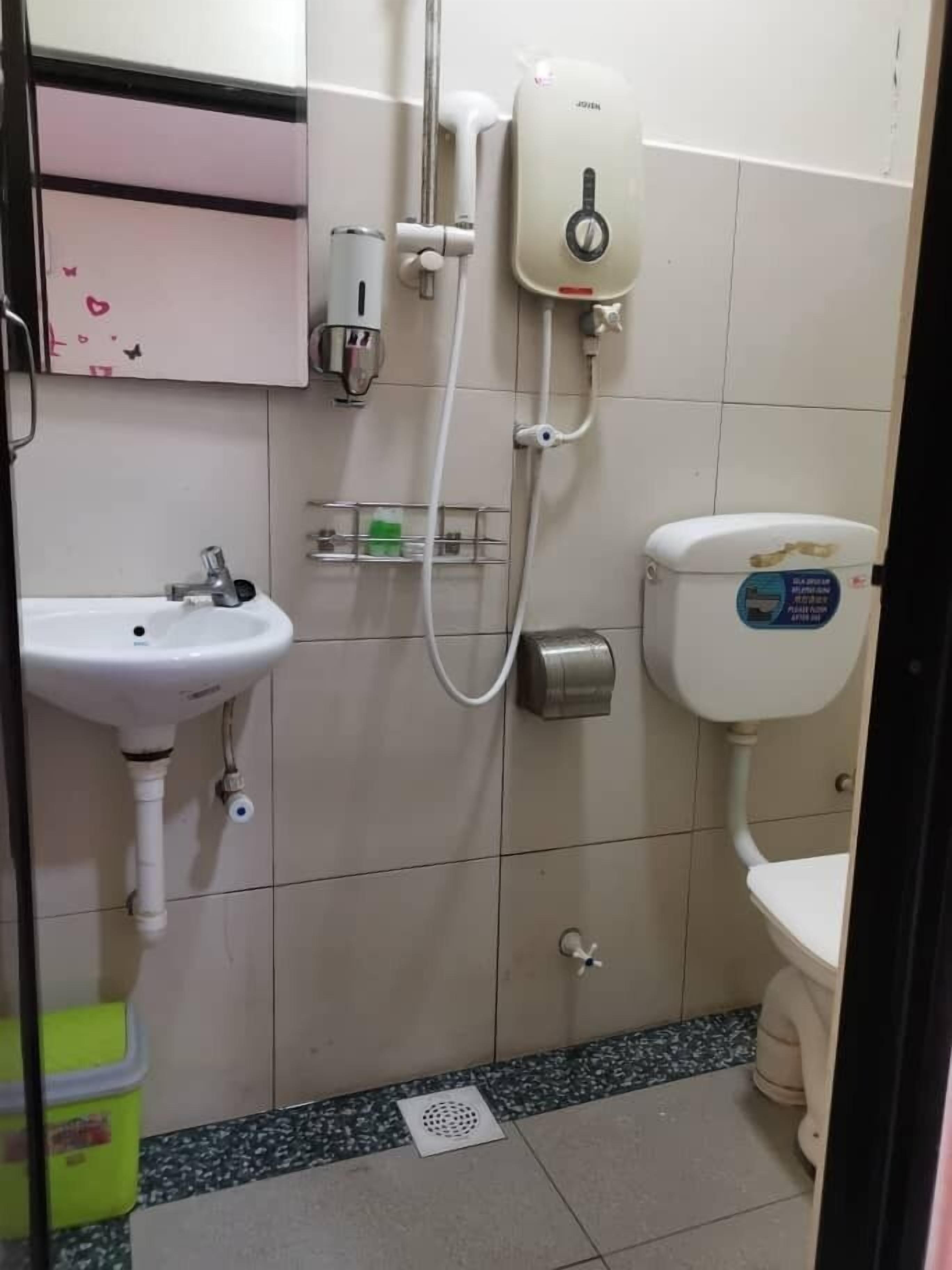 Um banheiro pequeno com pia branca, vaso sanitário e chuveiro.