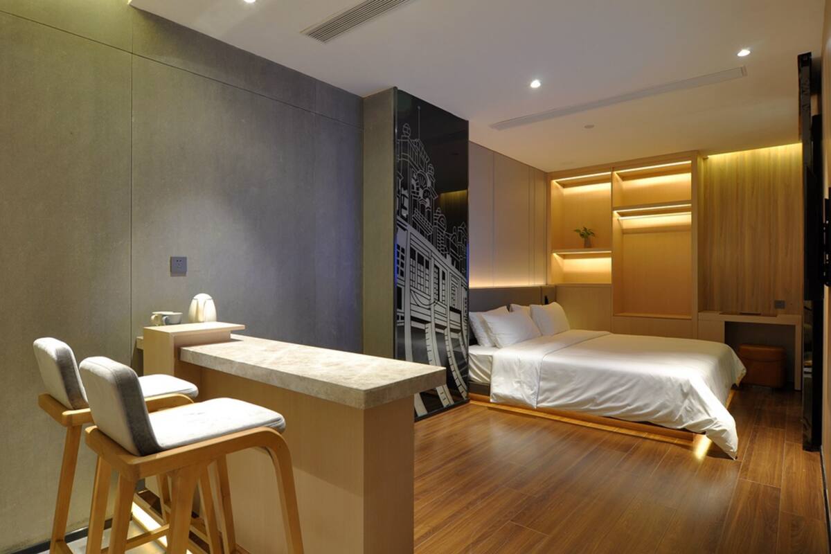 Ein Hotelzimmer mit einem Bett, einem Schreibtisch mit Stuhl und einer großen Wandmalerei.
