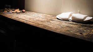 A wall with framed photographs and a wooden counter with towels. - Mas Julien (Orange)
