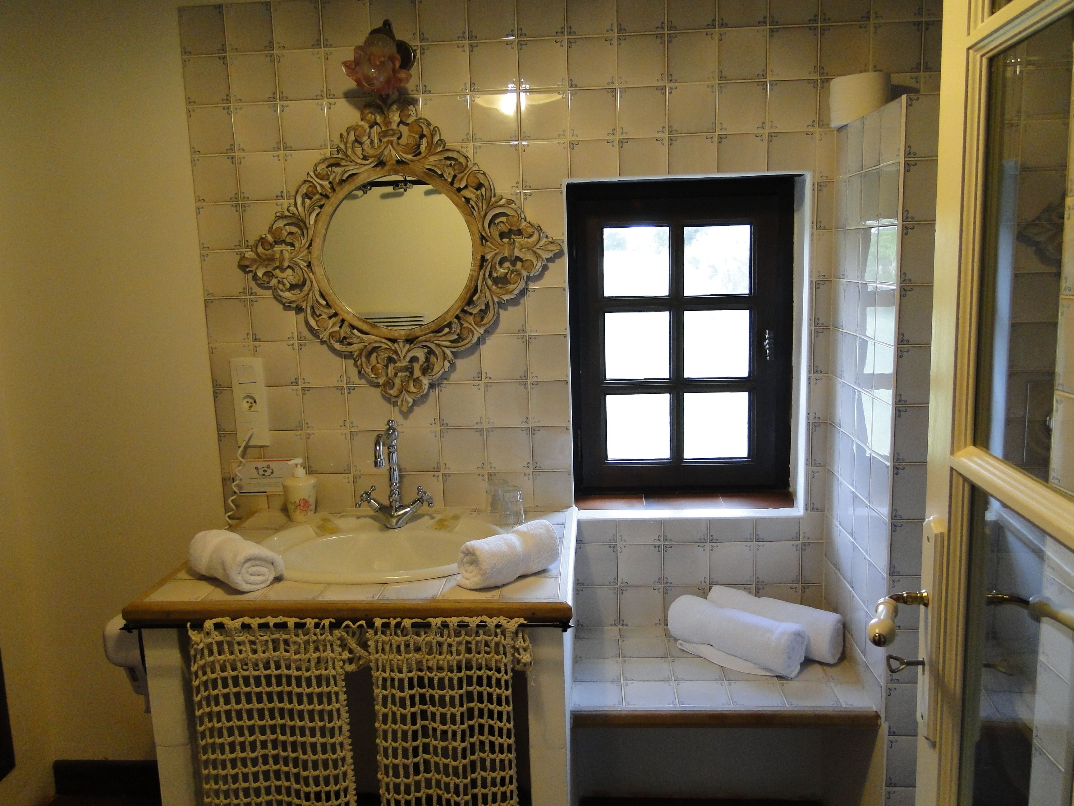 Ein Badezimmer mit Waschbecken, Spiegel und Fenster.