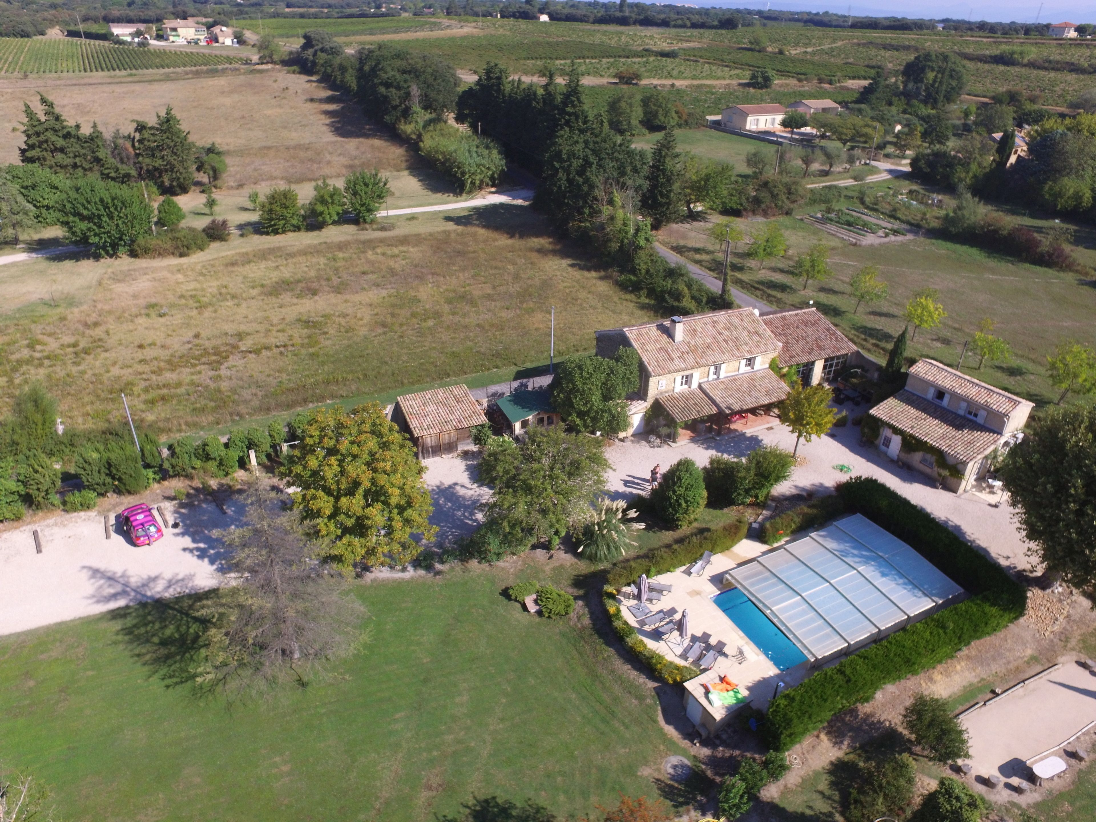 Vista aérea de una propiedad con una casa grande, piscina y campos circundantes.