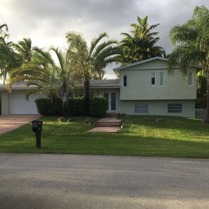 A single-story house with a front yard, a mailbox, and a garage. - Tropical Oasis Estate (Pinecrest)
