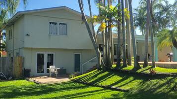 Stroll through the beautifully manicured lawn to the inviting patio area with a table and chairs.