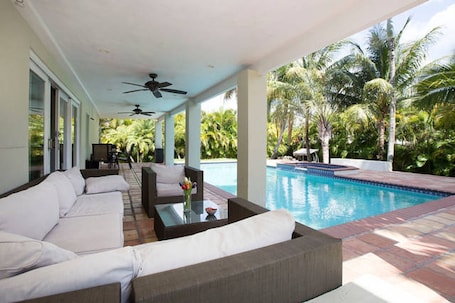 Una piscina al aire libre, sombrillas, sillones reclinables de piscina