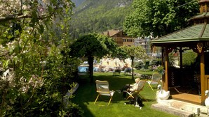 A garden with a gazebo, outdoor seating, and a mountain backdrop. - Alle Dolomiti Boutique Lake Hotel (Molveno)
