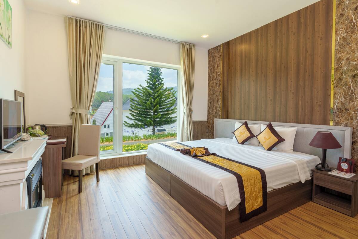 Ein modernes Hotelzimmer mit einem großen Bett, einem Schreibtisch und einem Fernseher.