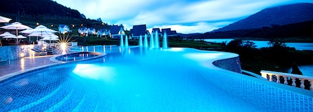 Una piscina al aire libre, sombrillas, sillones reclinables de piscina
