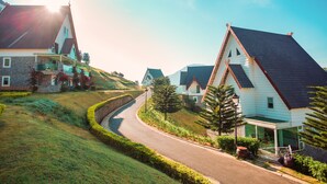 A residential street with houses, a curved road, and a clear sky. - Dalat Wonder Resort (Xuan Huong - Da Lat)