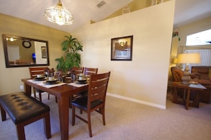 A dining area with a wooden table set for four, a bench, and a potted plant. - Ly53766 - Indian Ridge - 4 Bed 2 Baths Villa (Kissimmee)