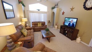 A living room with a sofa set, a coffee table, a television, and decorative items. - Ly53766 - Indian Ridge - 4 Bed 2 Baths Villa (Kissimmee)