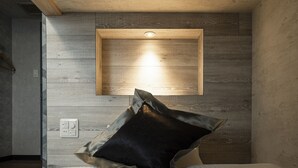 Un dormitorio con una cama, una lámpara de pared y un enchufe.