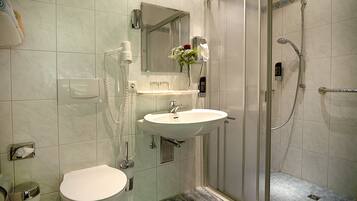 A bathroom with a toilet, sink, and shower.