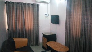 A small room with a sofa, a table, and a TV mounted on the wall. - Bayse One Executive Suites and Bar (Ibadan)