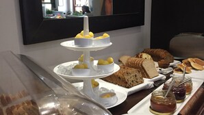 Zona de buffet amb una varietat d'aliments, com ara pastissos, pa i condiments.