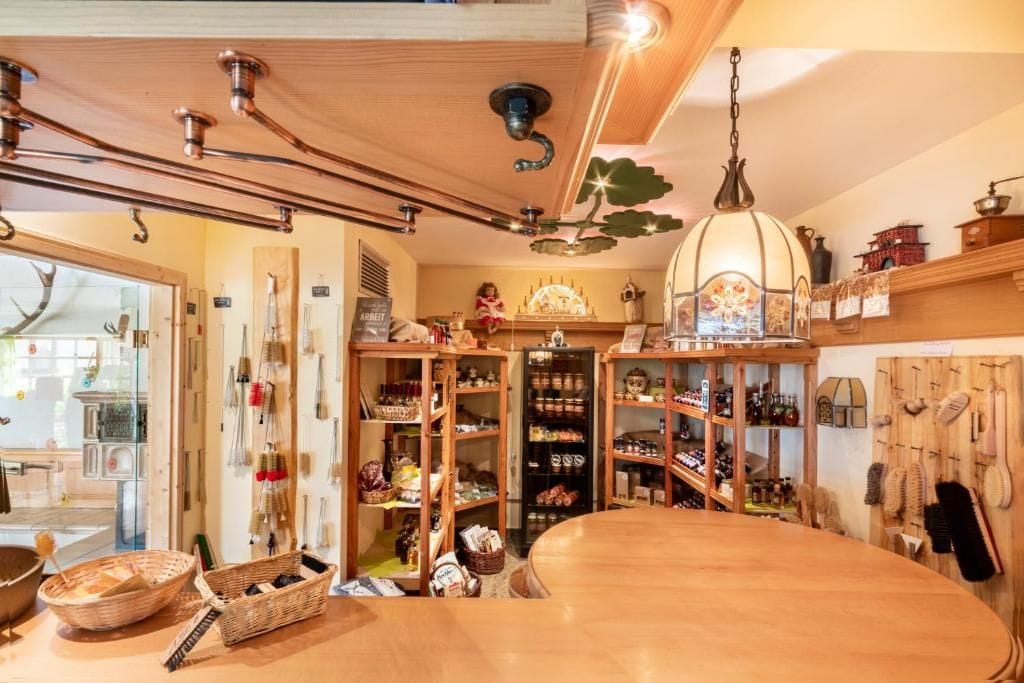 Eine Küche mit Holzschränken, einem großen Holztisch und hängenden Küchenutensilien.