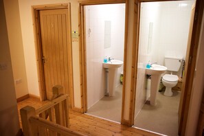 A wooden staircase leading to a bathroom with a sink and toilet.