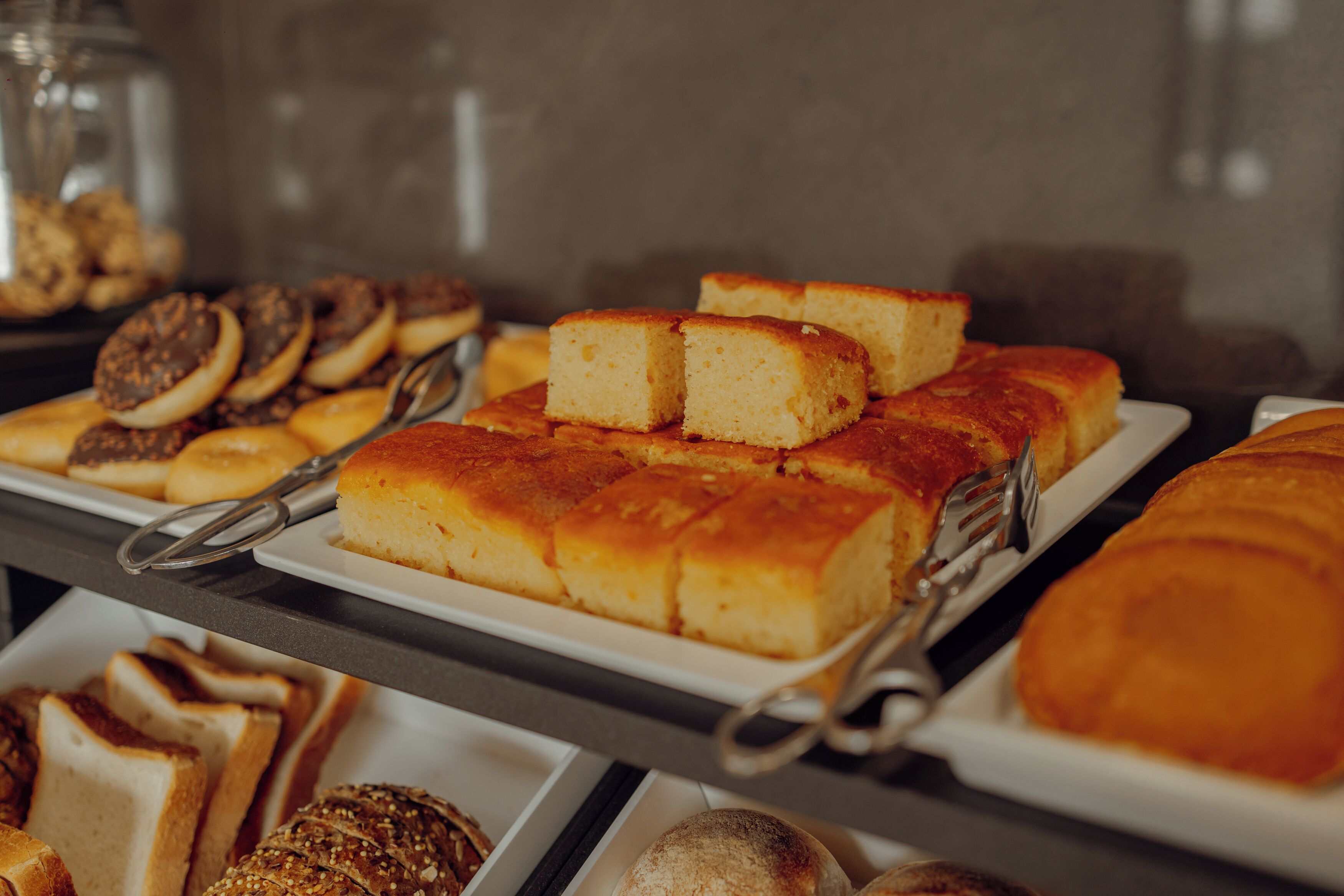 A buffet with various baked goods including cakes and pastries.