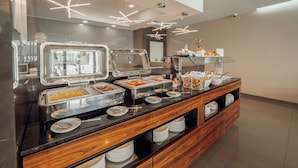 A buffet setup with various food items and utensils.
