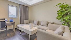 A modern hotel room with a sofa, a small desk, a coffee machine, and a large window. - Xana Lite Hotelle Shunyi (Shunyi)