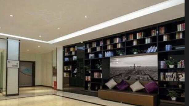 A modern lobby with a large bookshelf filled with books and a seating area with cushions. - Xana Lite Hotelle Shunyi (Shunyi)