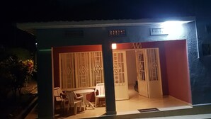 A small, single-story building with a brightly lit entrance. - Tinho Guest House (Kigali)