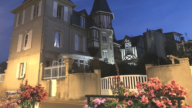 Un grand bâtiment historique, doté de plusieurs étages et d’une tour imposante.