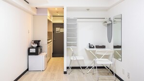 A modern bathroom with a shower, a mirror, and a small table. - G-stays Shinjuku (Tokyo)