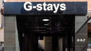 The entrance to G-stays with a reception area and a sign indicating the address 2-3-7. - G-stays Shinjuku (Tokyo)