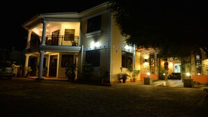 A two-story building with a balcony, potted plants, and a paved entrance area. - Royal Victoria House (Kampala)