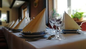 A dining table set with plates, cutlery, and napkins. - Hotel & Gasthaus Zum Domkreuger (Walsrode)