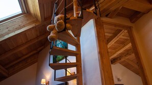 Una camera da letto in stile loft con una scala in legno, un letto e una finestra.